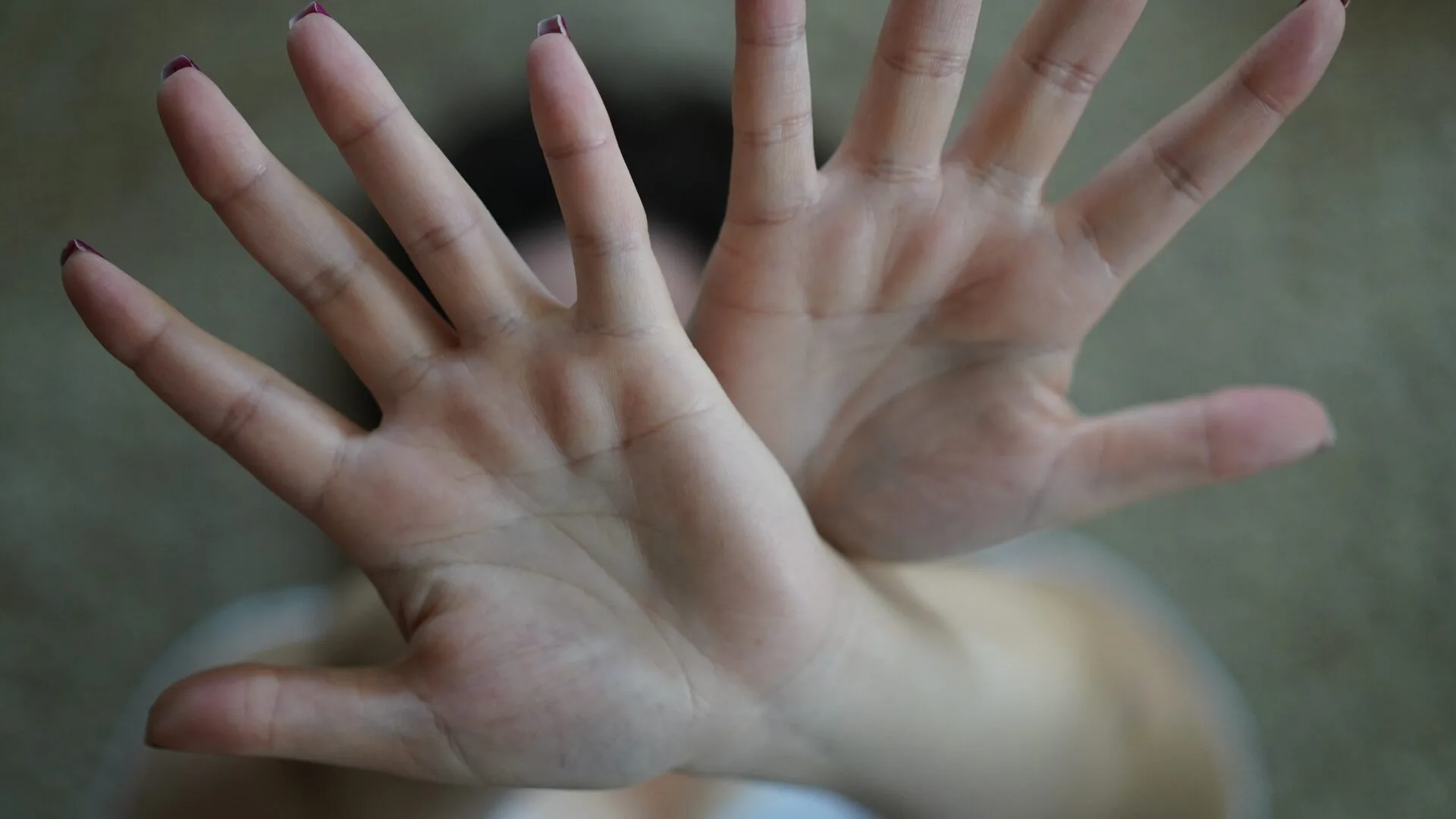 両手を前に突き出し、拒絶のポーズをとる人物
