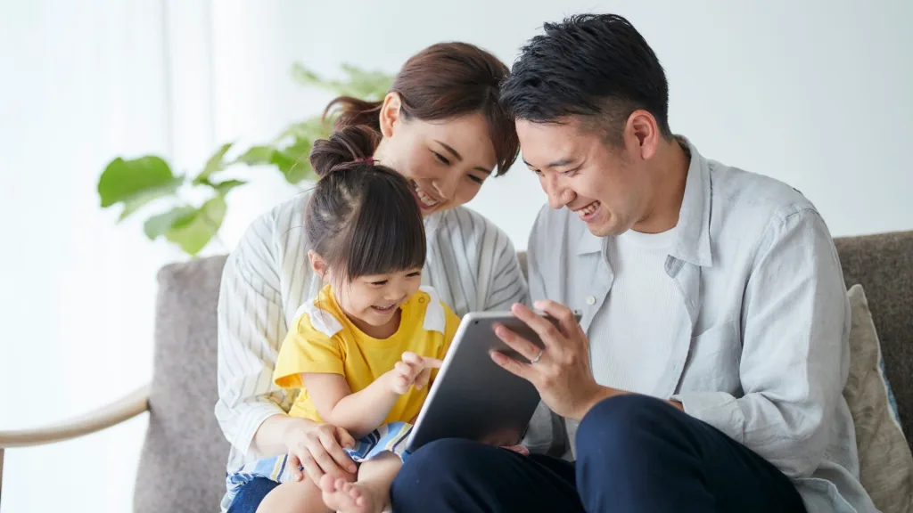 リビングのソファに座り、親子3人で仲良くタブレットを見ている