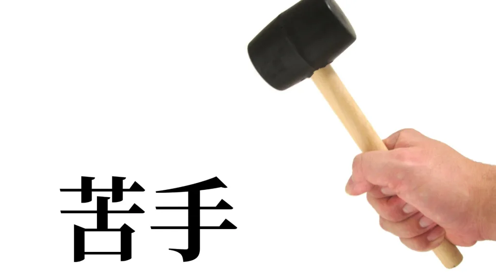 「苦手」という漢字を、ハンマーで叩き壊そうとしているイメージ