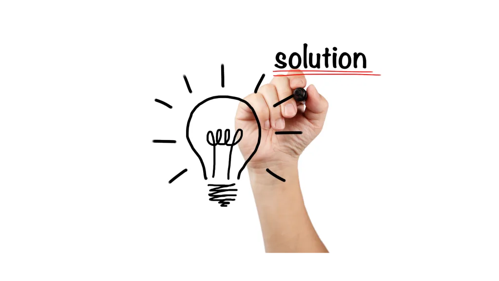 ペンで描かれた電球のイラストの横に、「solution」という単語を書き加えている先生の手
